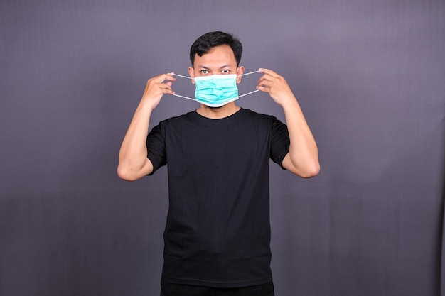 Asian man wearing a mouth protection or mask to prevent getting sick at work.