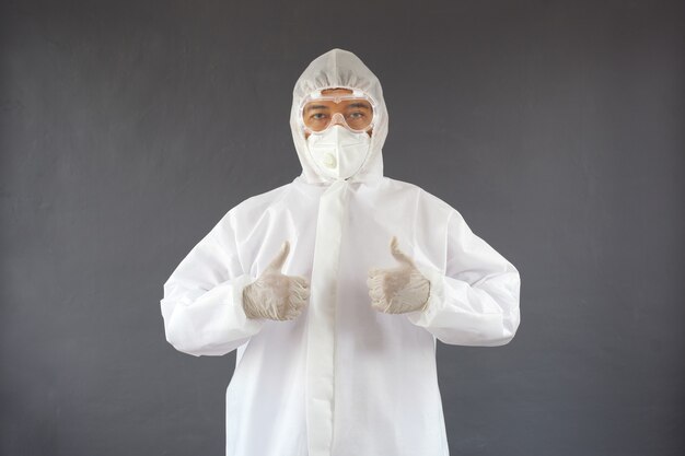 Asian man wearing PPE suit giving thumbs up with both hands