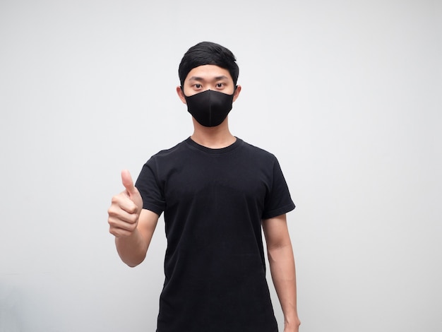 Asian man wearing protect mask show thumb up looking at camera white background