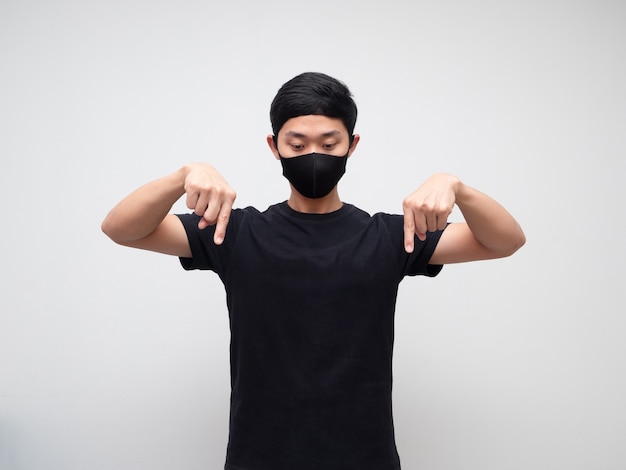 Asian man weraing mask point double finger and look down on white background