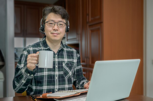 An Asian man who is self-isolated and working from home because of a massive pandemic.