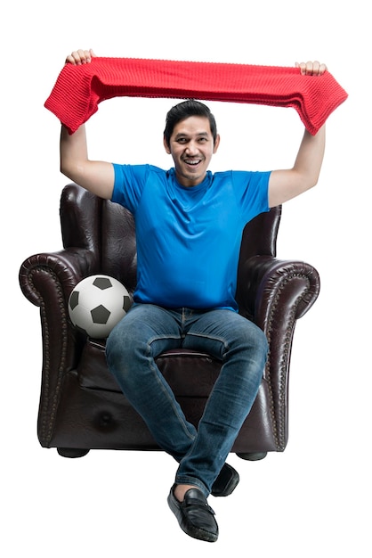 Asian man with the ball holding scarf sitting on the couch with an excited expression