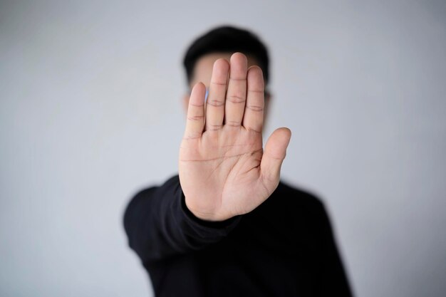 An asian man with a beard wears a white tshirt stretching out\
his hands