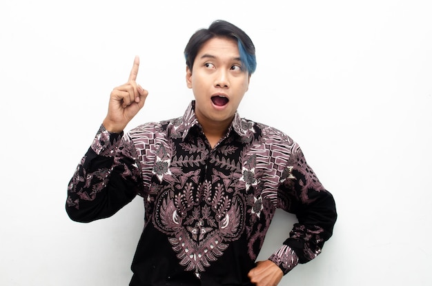 asian man with blue peek a boo hair wearing indonesian batik pointing and promoting something goods