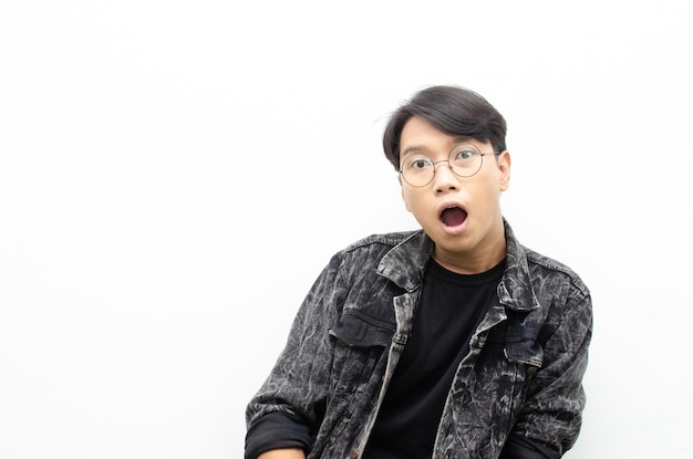 Asian man with glasses oprning mouth expressing shock and surprise with a wow look