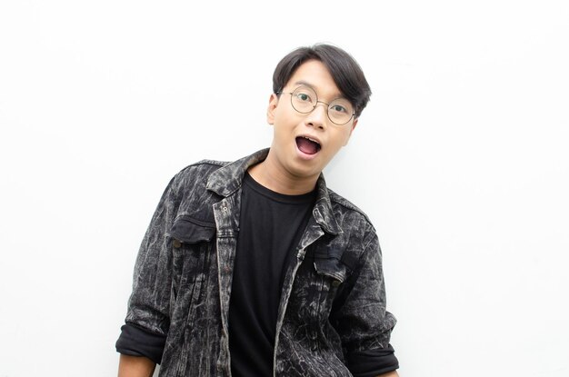 Asian man with glasses oprning mouth expressing shock and surprise with a wow look