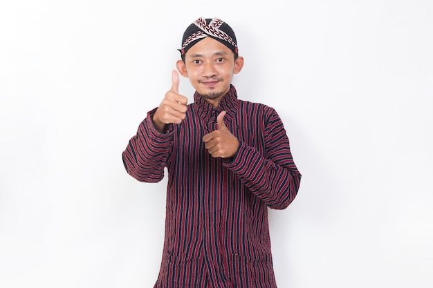 asian man with javanese traditional cloth lurik with ok sign gesture tumb up isolated on white