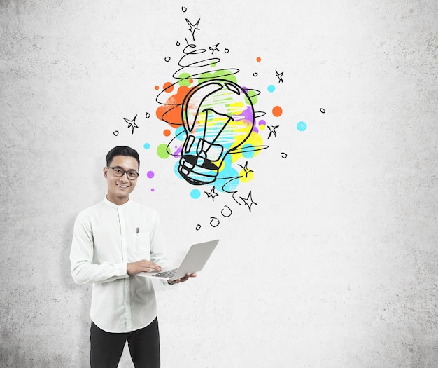 Asian man with laptop and light bulb sketch