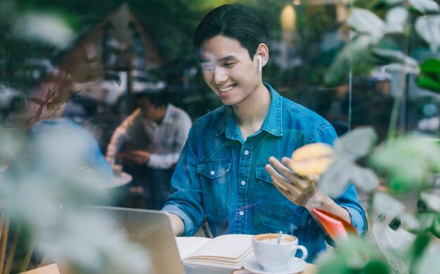 Uomo asiatico che lavora al caffè nel fine settimana