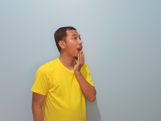 写真 アジア人男性の黄色の t シャツのショック表現