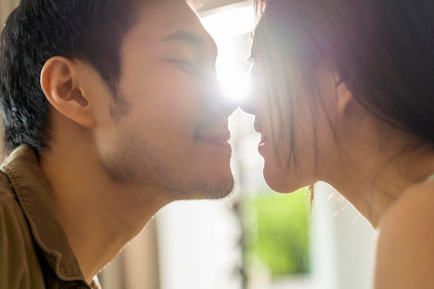 Азиатский брак Влюбленная пара делится искренними эмоциями и счастьем, обнимаясь на балконе, утренний свет в концепции изоляции дома в спальне