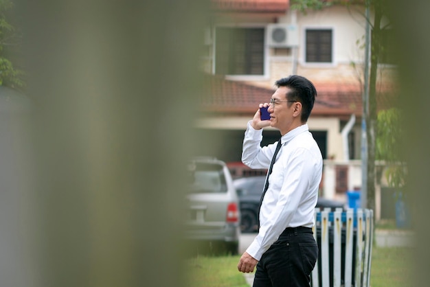 Asian mature businessman having a phone call outdoor