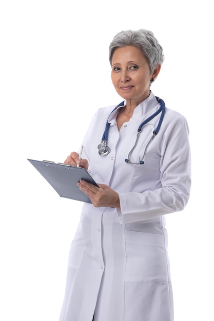 Asian mature female medical doctor with stethoscope taking notes isolated on white background