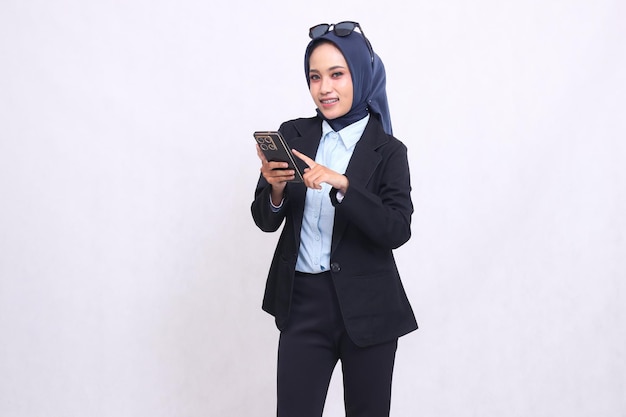 Asian mature office woman in hijab standing cheerful smile looking at camera carrying and pressing