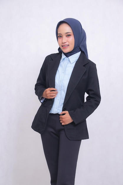 Asian mature office woman wearing blue shirt hijab standing smiling cheerfully holding jacket up and