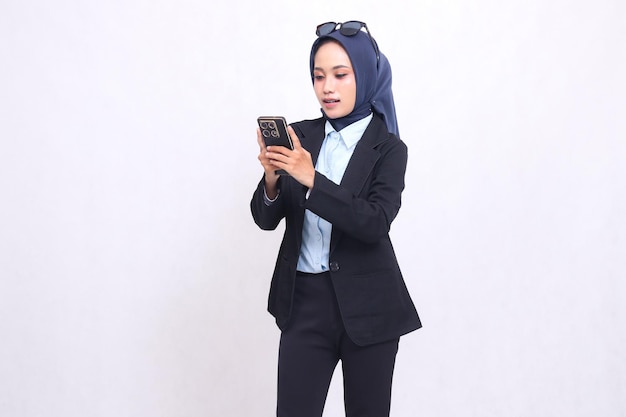 Asian mature office woman wearing a hijab stands carrying a smartphone gadget for online shopping ad