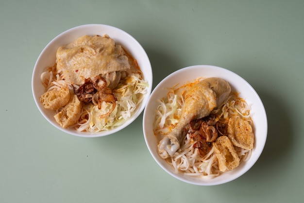 Фото Азиатское блюдо острый суп с лапшой лакса и пастой из белого карри с курицей и овощами из сингапура