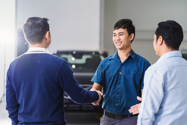 Asian Mechanic handshake with the customer and leader in maintenance service center