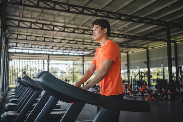 Photo asian men are happy jogging and running on a treadmill at gym a man is jogging and doing cardio training healthy lifestyle concept doing exercise for longer life
