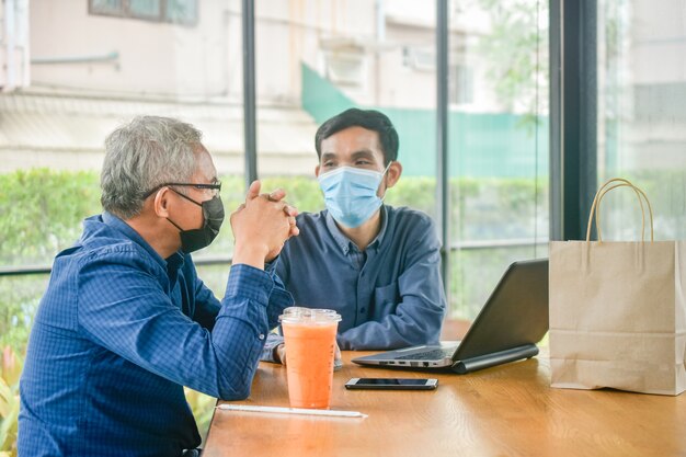 Asian men with mask at meeting