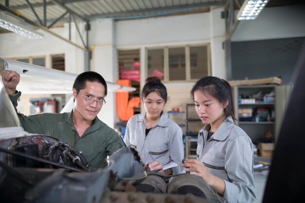 Asian men and women Engineers and technicians are repairing aircraft.