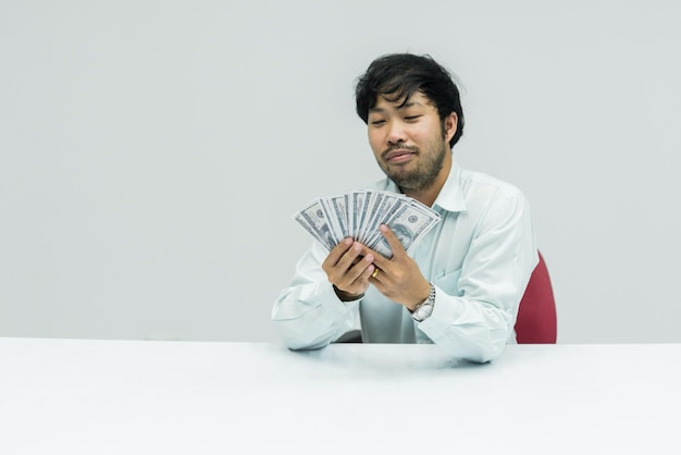 Asian messy businessman with a lot dollar money in hand on white background