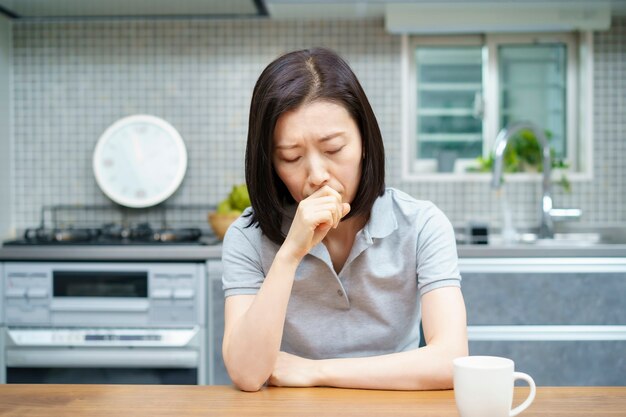 방에 피곤한 표정으로 아시아 중간 나이 든된 여자