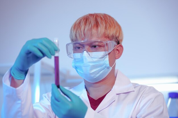 Photo asian middleaged male scientist conducts research in a laboratory