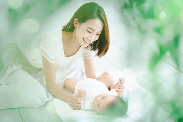 Asian mom and baby playing indoors