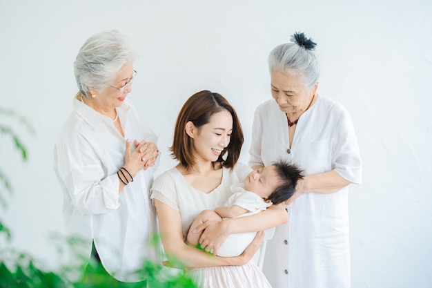 Asian mom holding a baby and two senior women