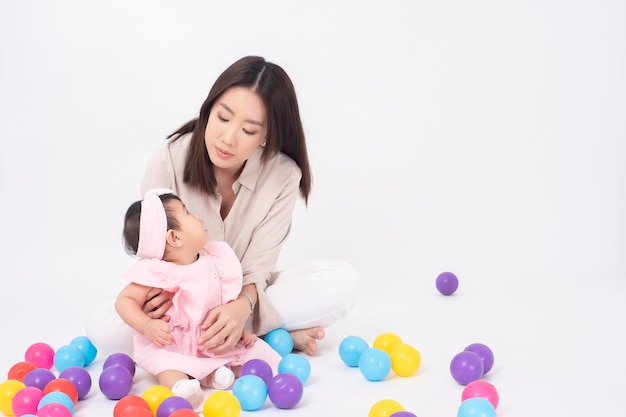 Asian mother and adorable baby girl are  happy on white wall