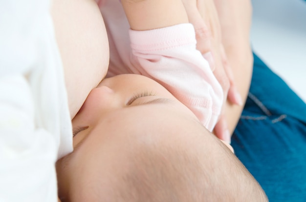 Foto madre asiatica che allatta al seno la sua bambina