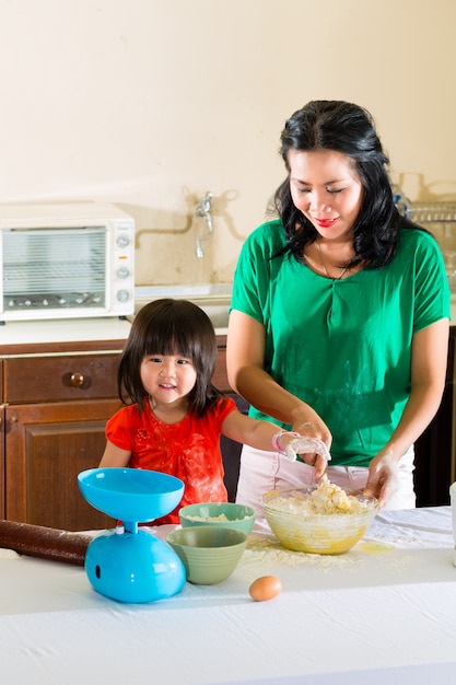 Asian Mother and daughter at home in kitchen