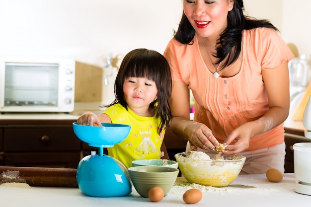 Madre e figlia asiatiche a casa in cucina