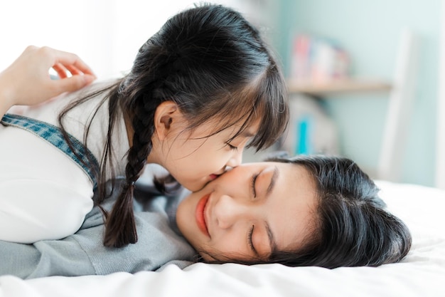 Asian mother and daughter image in bed