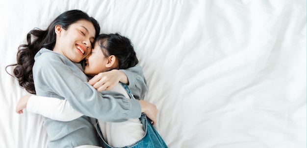 Asian mother and daughter image in bed