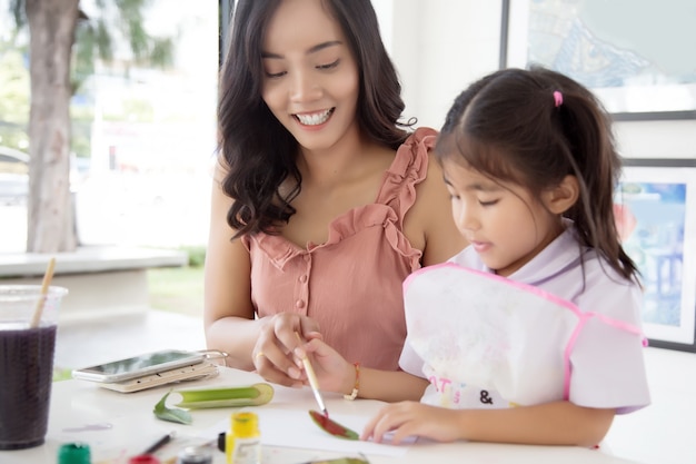 Asian mother and daughter painting water color