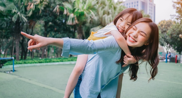 Asian mother and daughter playing together at park