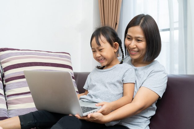 Asian mother and daughter using laptop 