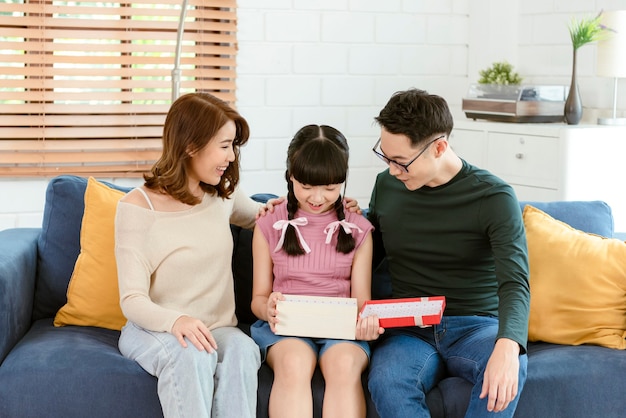 Asian mother and father give present for daughter. concept surprise gift box for happy birthday.