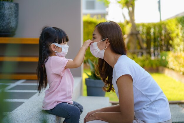 Asian mother help her daughter wearing protection mask