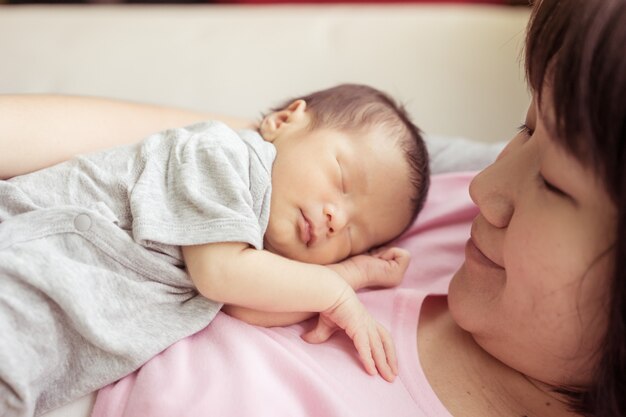 Asian mother holds her  newborn baby