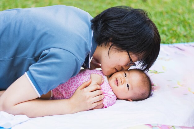 사진 아시아 어머니는 공원에서 그녀의 아기 키스