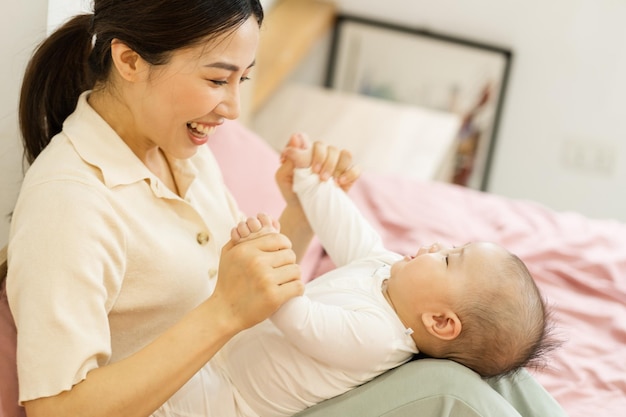 Asian mother and newborn baby feet are smiling and happy