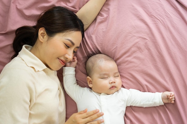 アジアの母親と生まれたばかりの赤ちゃんの足は笑顔で幸せです