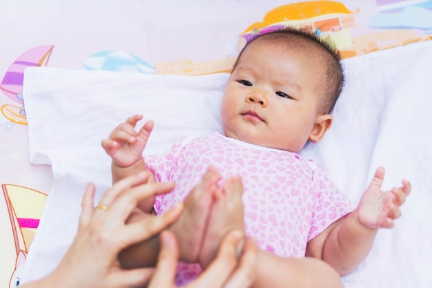 Asian mother playing and taking care of  baby at park