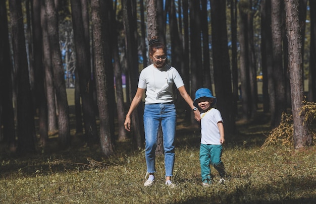 Asian mother and son in nature garden with outdoor sun lighting.