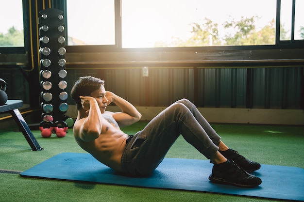 Asian Muscular man exercising doing sit up exercise