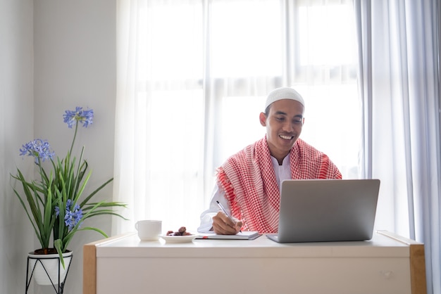 Asian muslim businessman working using laptop while sitting on the desk