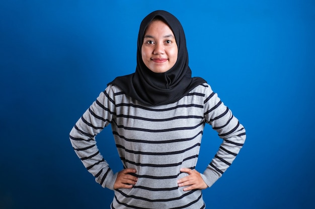 팔짱을 끼고 웃고 있는 히잡을 쓴 아시아 이슬람 대학생 소녀